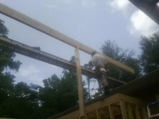 Carpenter setting a ridge beam over a new addition frame — Ice Dam Removal by Roofing Brothers in Allardt