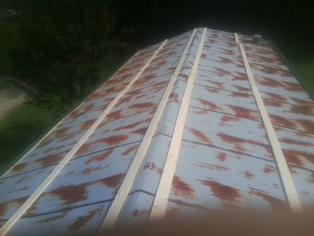 Rusted metal roof panels with new wood purlins before replacement — Storm Damage Roof Repair in Allardt by Roofing Brothers
