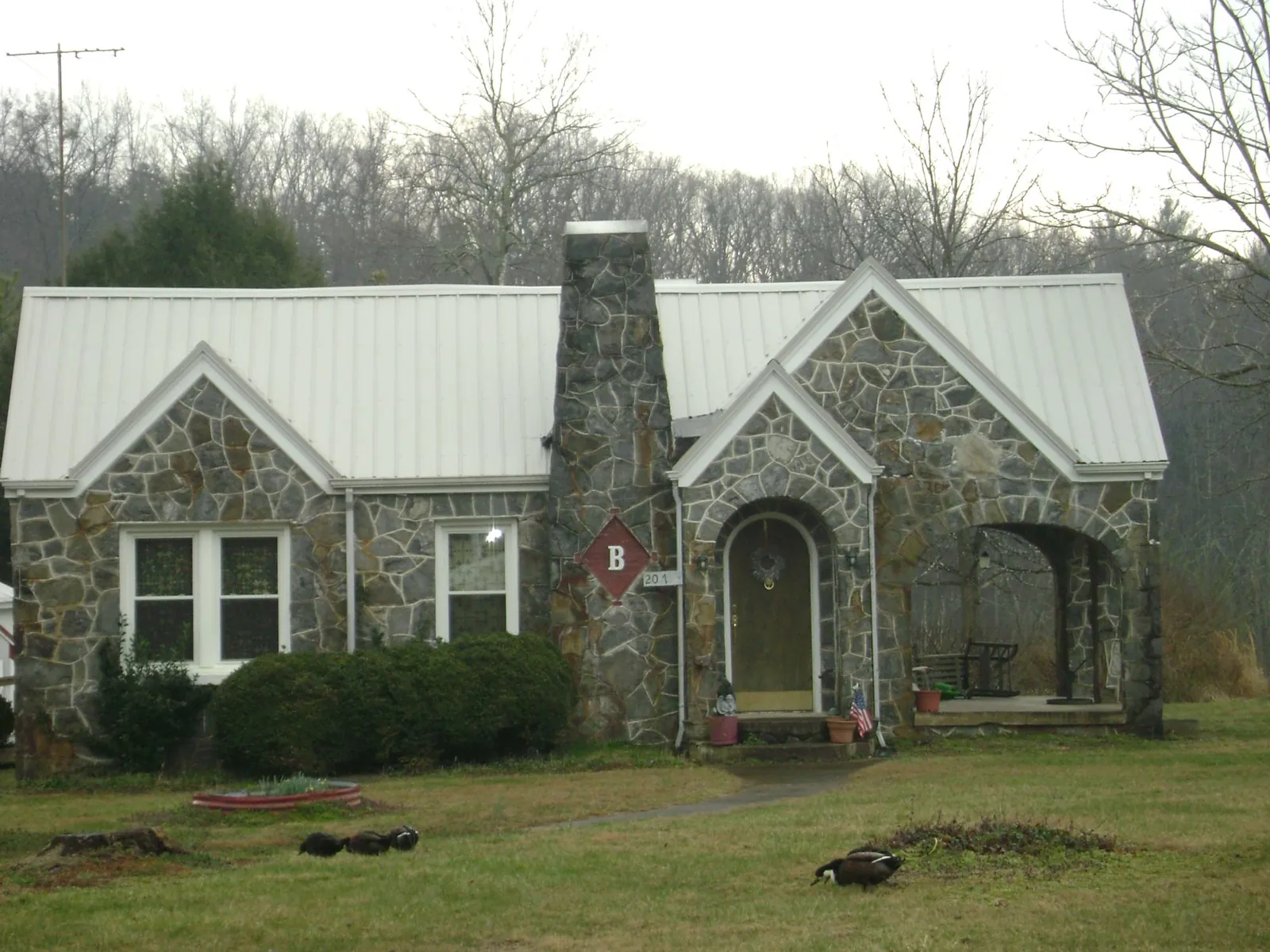 White metal roof on a stone cottage with steep gables in Allardt