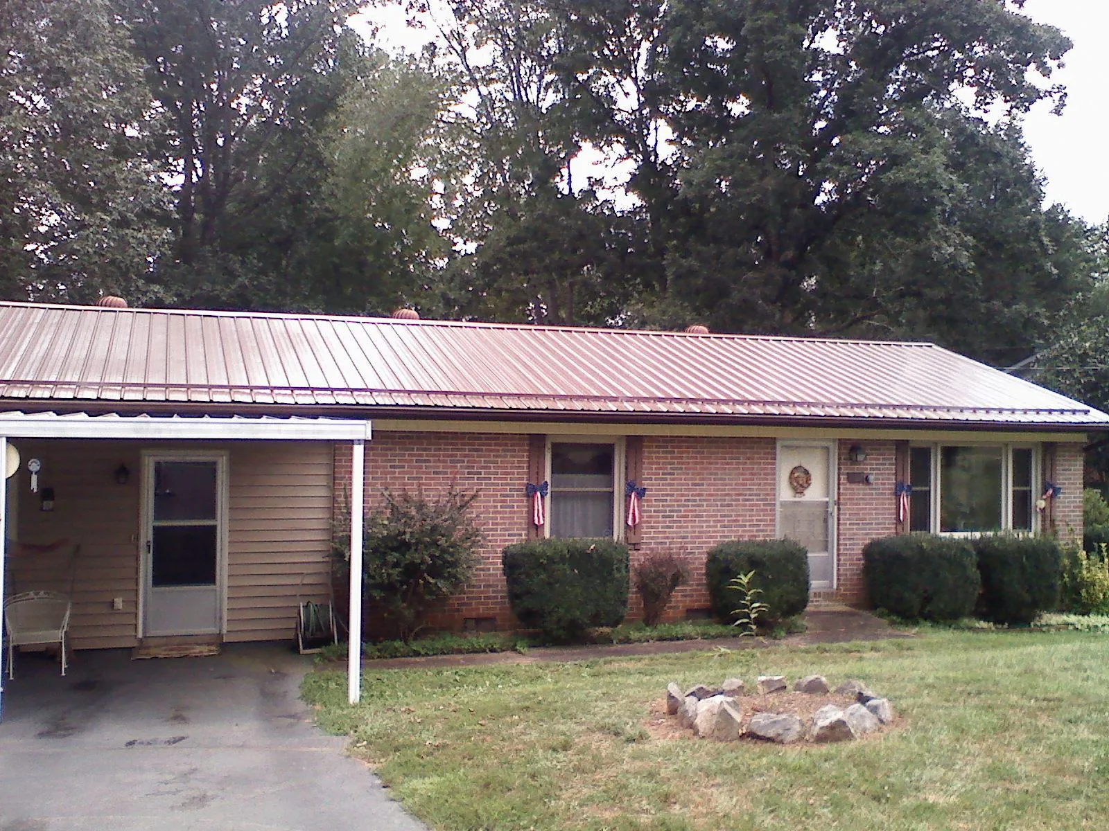 Bronze metal roof and carport on a brick ranch home — Roof Repair work by our crew in Allardt